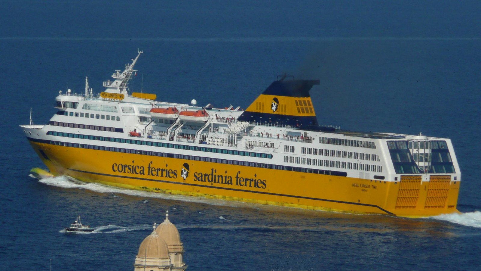 Le départ du Mega Express Two de la Corsica Ferries, vu des hauteurs de la ville, en juillet 2013 (au premier plan, le sommet de l'église St Jean) ; photo : Romain Roussel