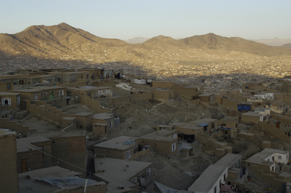 Kaboul vue d'en haut : des maisons en brique de terre séchée à perte de vue dans une cuvette entre les montagnes